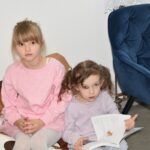 Dzień Kota – dziewczynki z grupy 5-latków przeglądają na pufie książkę o kotach