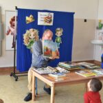 Bibliotekarz przedstawia przedszkolakowi ilustracje książki